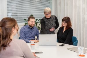 Tilitoimiston työntekijöitä pöydän ääressä